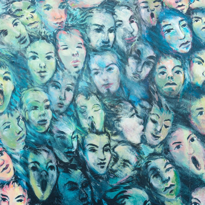 faces painted on Berlin Wall