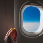 Hand holding earplugs on airplane