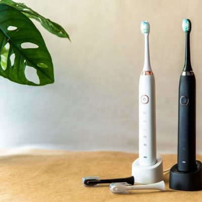 Two electric toothbrushes sitting on counter