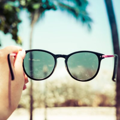 Woman holding a pair of sunglasses