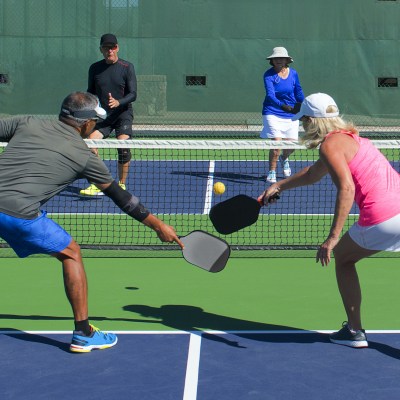 Mixed doubles pickleball action on colorful court