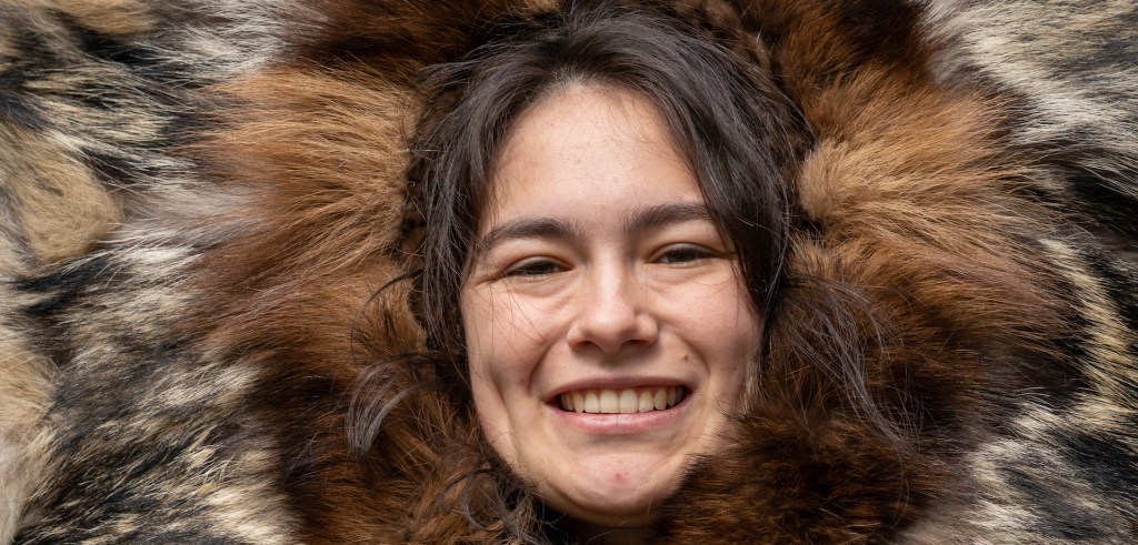 A local native Athabascan guide wears traditional winter dress in a re-created village in Fairbanks, Alaska.