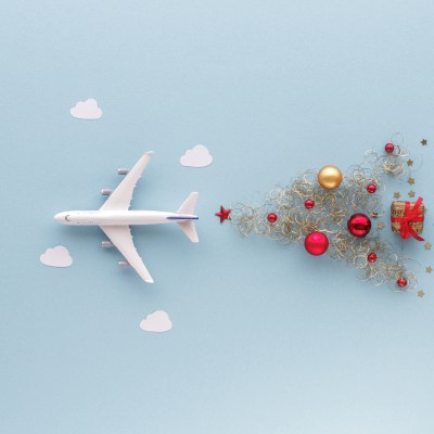 Christmas composition. Airplane flying in sky star gift bauble top view
