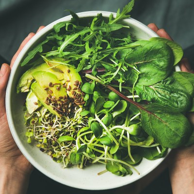 A plant-based meal with avocado, bean sprouts, and leafy greens