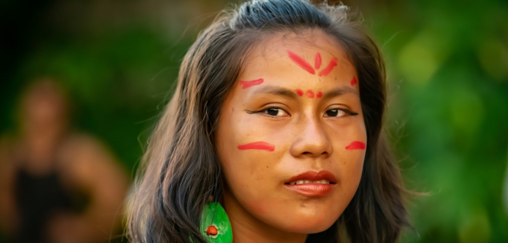 Dressed in traditional Ribereños attire, a young woman and her river village meets a group of guests from the Zafiro luxury cruise with Jungle Experiences.