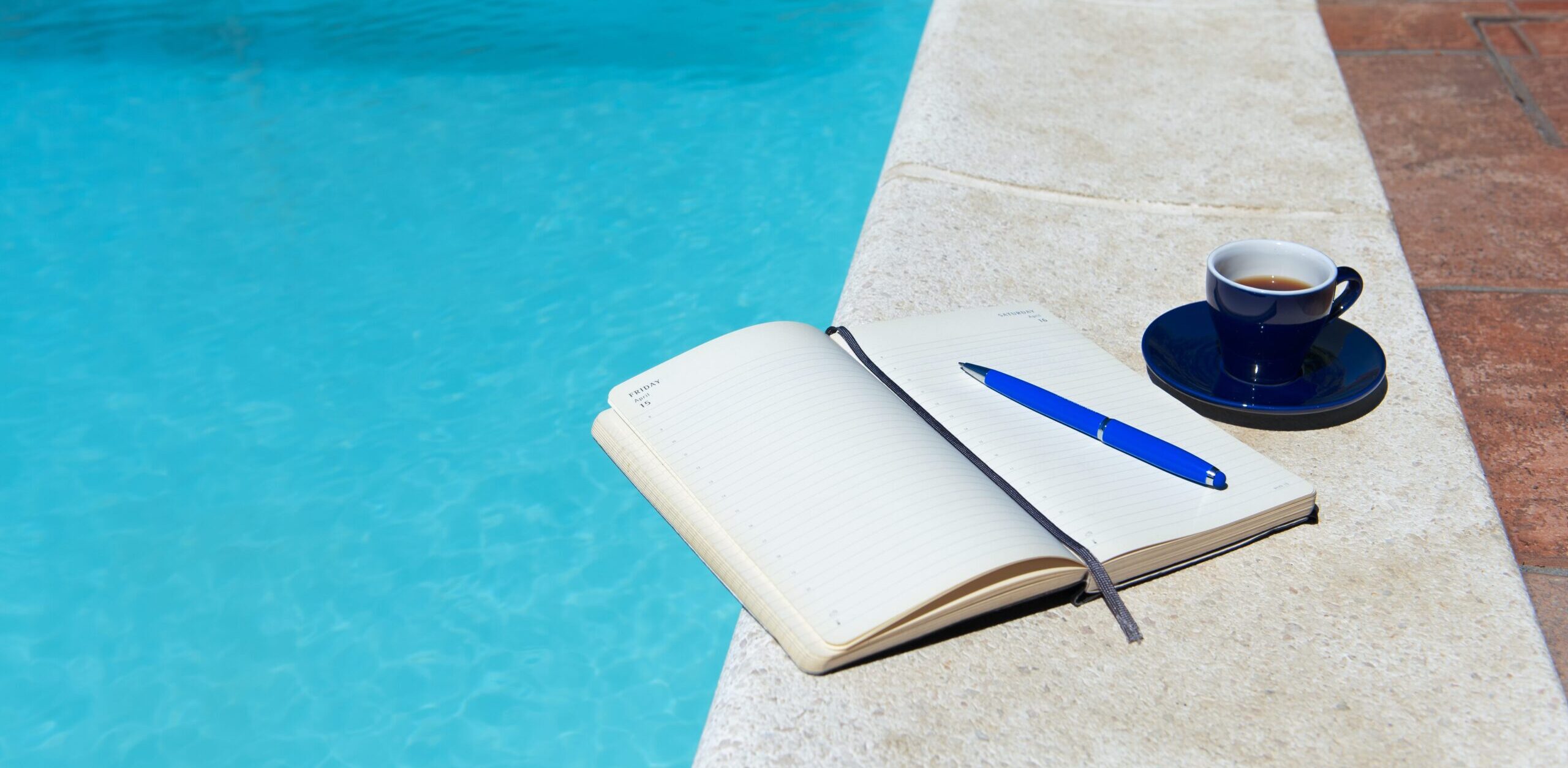 Travel Journal and Cup of Coffee by Pool