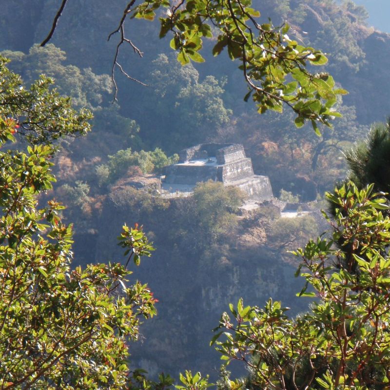 Tree-lined view of the Tepozteco Pyramid from Tepozteco National Park, Mexico