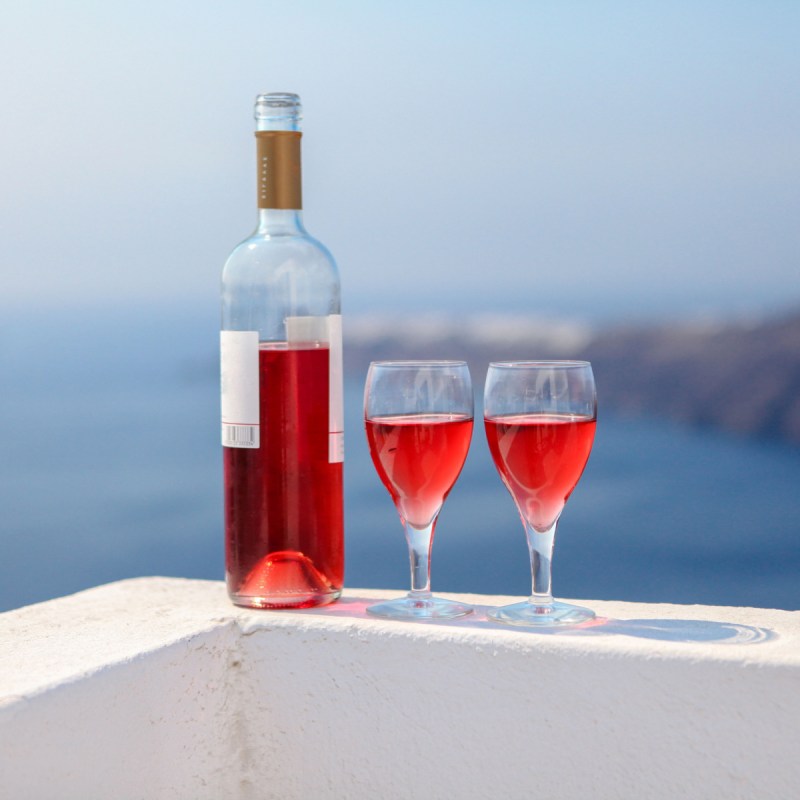 Bottle of wine with two glasses near ocean