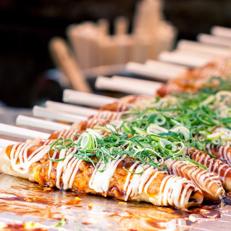 Okonomiyaki on wooden sticks at Nishiki market, Kyoto, Japan