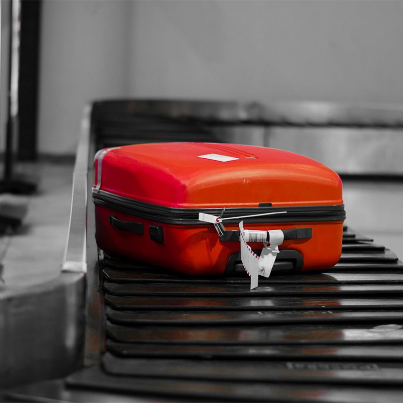 Red luggage airport conveyor belt