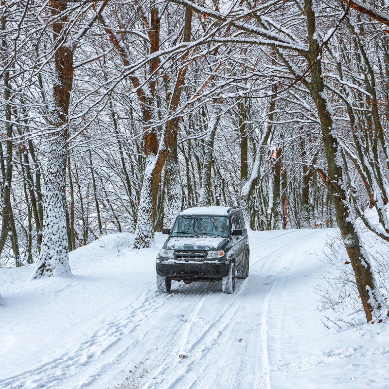 single car on a winter road in the forest. Lots of snow at winter