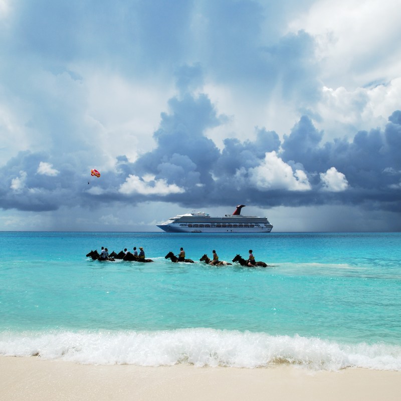 A group of tourists riding horses in Half Moon Cay