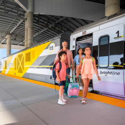 Family exiting a Brightline train car at the new Orlando station.