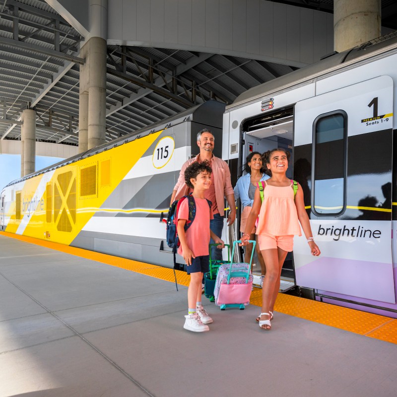 Family exiting a Brightline train car at the new Orlando station.