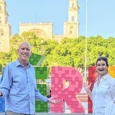 Edd and Cynthia in front of the Mérida sign at Plaza Grande