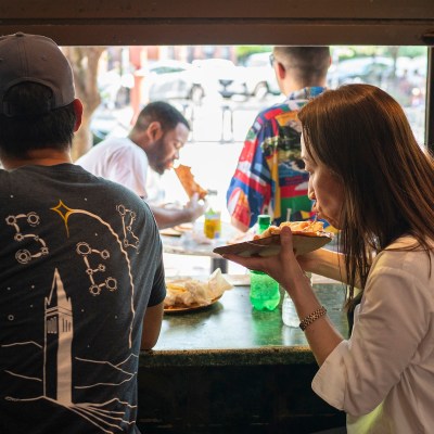 People enjoying Joe's Pizza in NYC's Greenwich Village