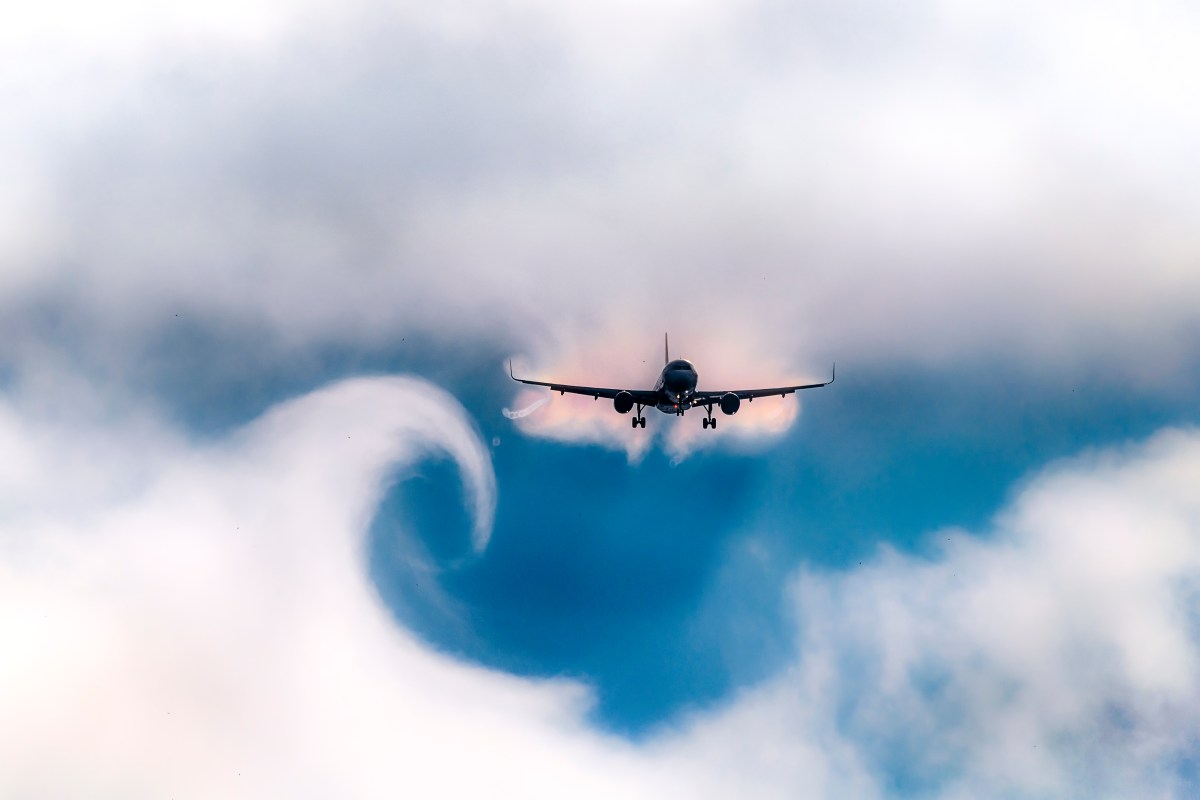 Cloud curve left behind by wake turbulence as a plane passes through the sky